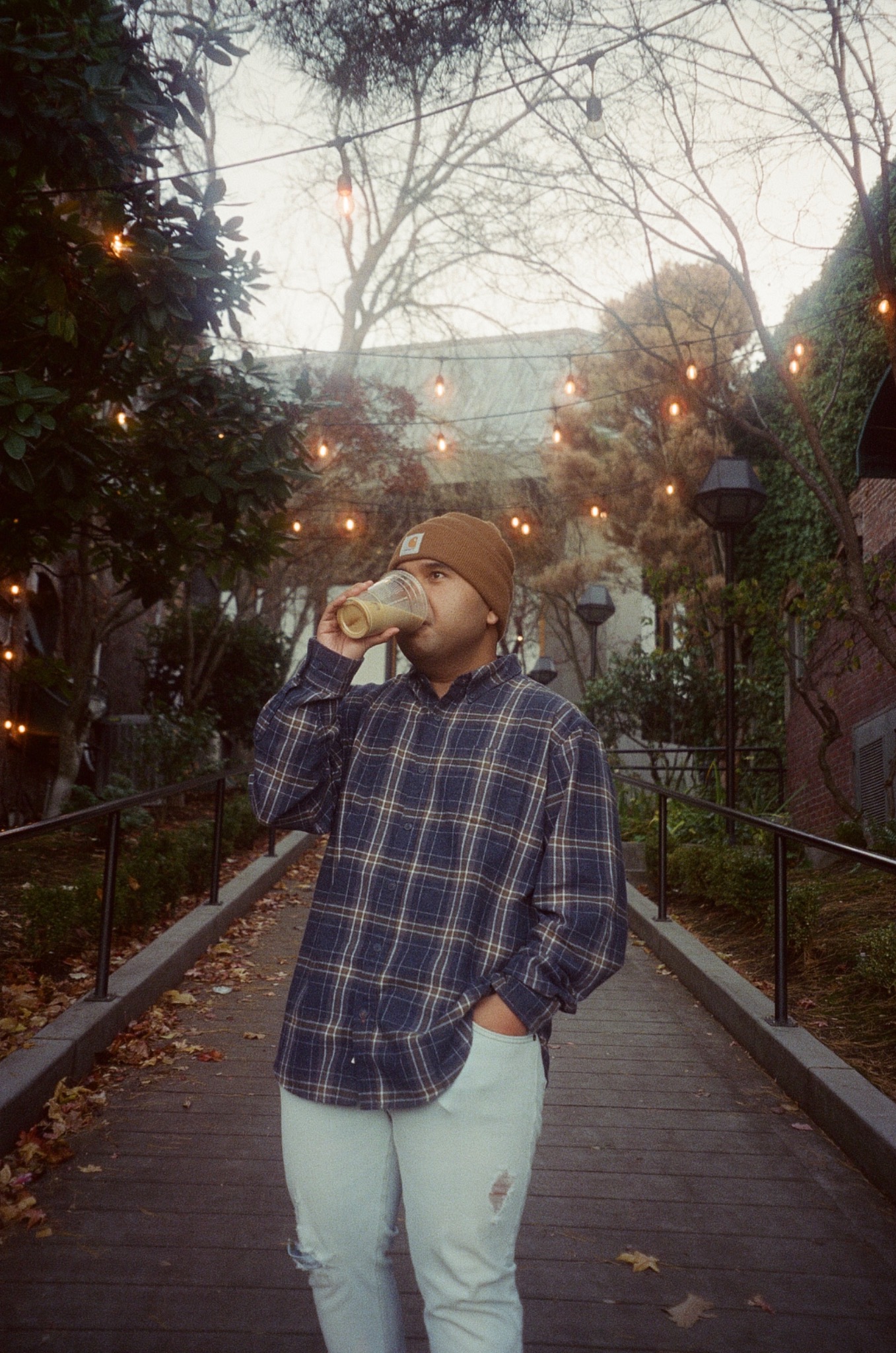 Kevin Boringot drinking coffee beneath garden lights